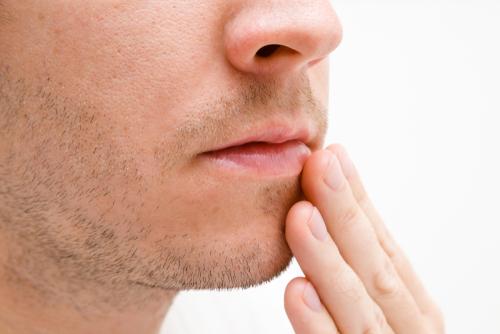 كيفية تفتيح الشفة العلوية الداكنة: 7 علاجات ونصائح منزلية - skin-beauty man touching lips - كيفية تفتيح الشفة العلوية الداكنة: 7 علاجات ونصائح منزلية