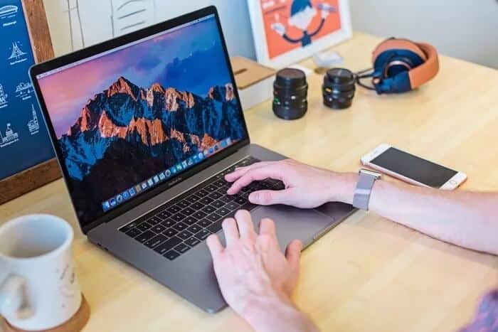 macbook-on-table-with-coffee_935adec67b324b146ff212ec4c69054f كيفية تغيير حساسية لوحة اللمس على جهاز Mac