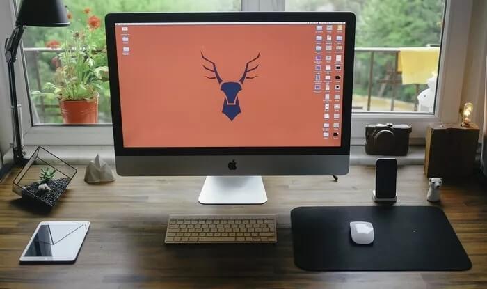 mac-on-desk-next-to-ipad_935adec67b324b146ff212ec4c69054f أفضل 5 تعديلات لإعدادات شاشة Mac للاستمتاع بصور أفضل