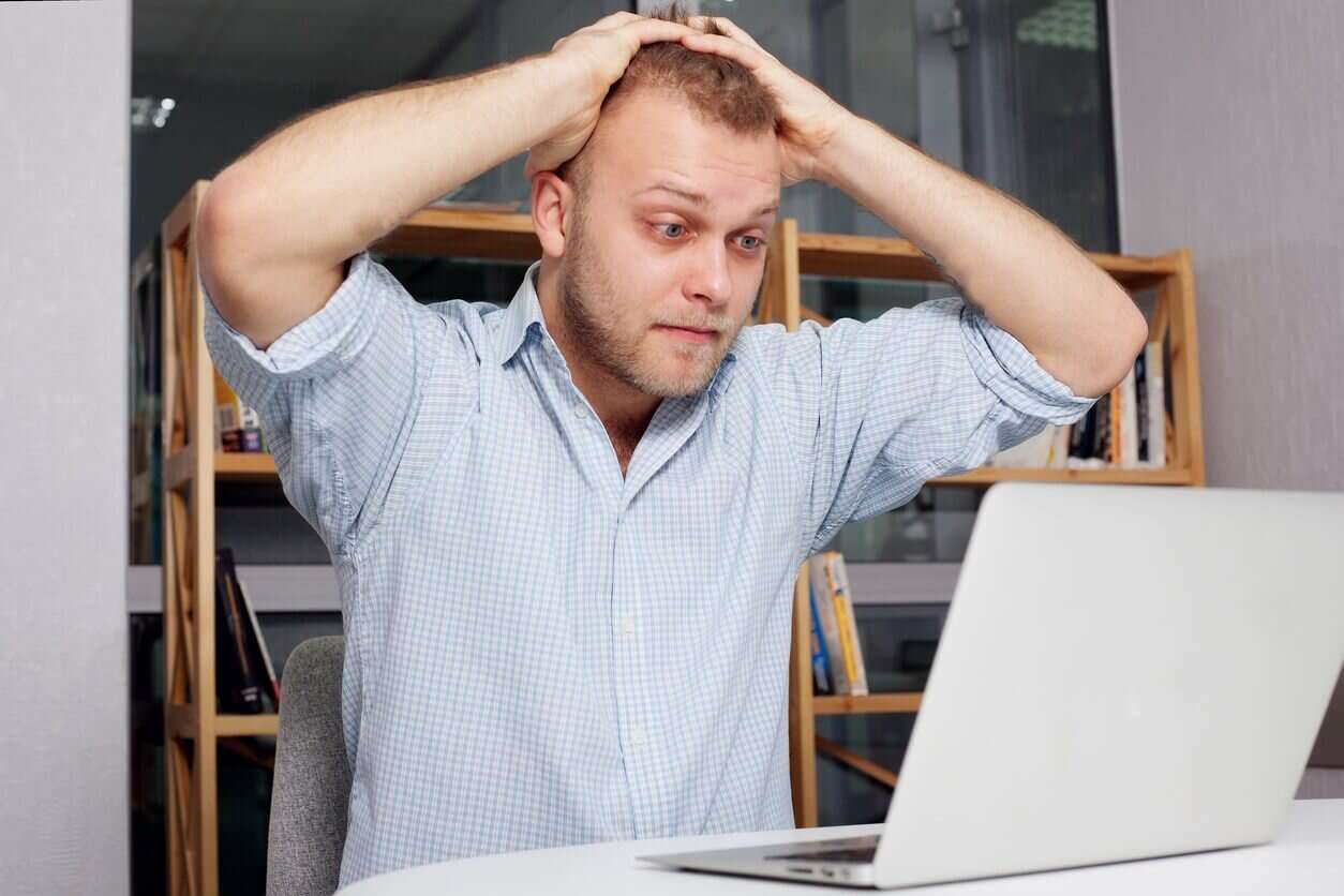 Young-businessman-at-his-desk-looking-fearfully-1254x836 ماذا يعني OFC وكيف يمكنني استخدامه؟