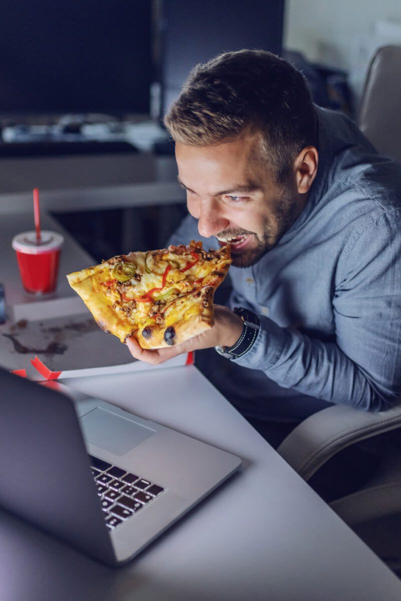 Man-eating-pizza-at-night-800x1200-1 كيف يؤثر تناول الطعام في وقت متأخر من الليل على نومك ووزنك