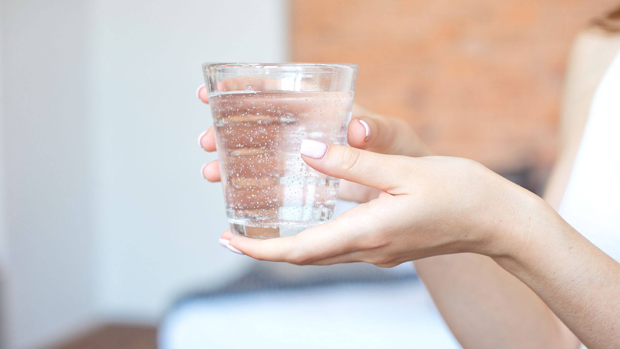 9 علاجات منزلية للمساعدة في مكافحة عدوى الكلى - urinary-tract-health female hands holding a clear glass of water a glass of clean mineral water in hands healthy drink 1158040705 801a1dae31b24b7cbb353a4d62c8197e 2119x1192 - 9 علاجات منزلية للمساعدة في مكافحة عدوى الكلى