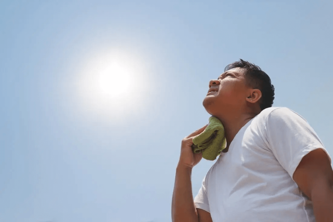 10 conseils pour prévenir les coups de soleil homme au soleil tenant un chiffon humide sur le cou - 10 conseils pour prévenir les coups de chaleur