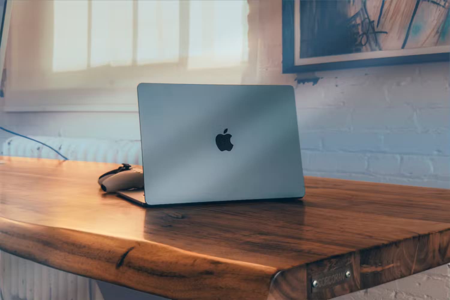 a-macbook-air-under-a-wooden-table 8 حيل أستخدمها للحفاظ على نظافة جهاز MacBook الخاص بي (دون إتلافه)