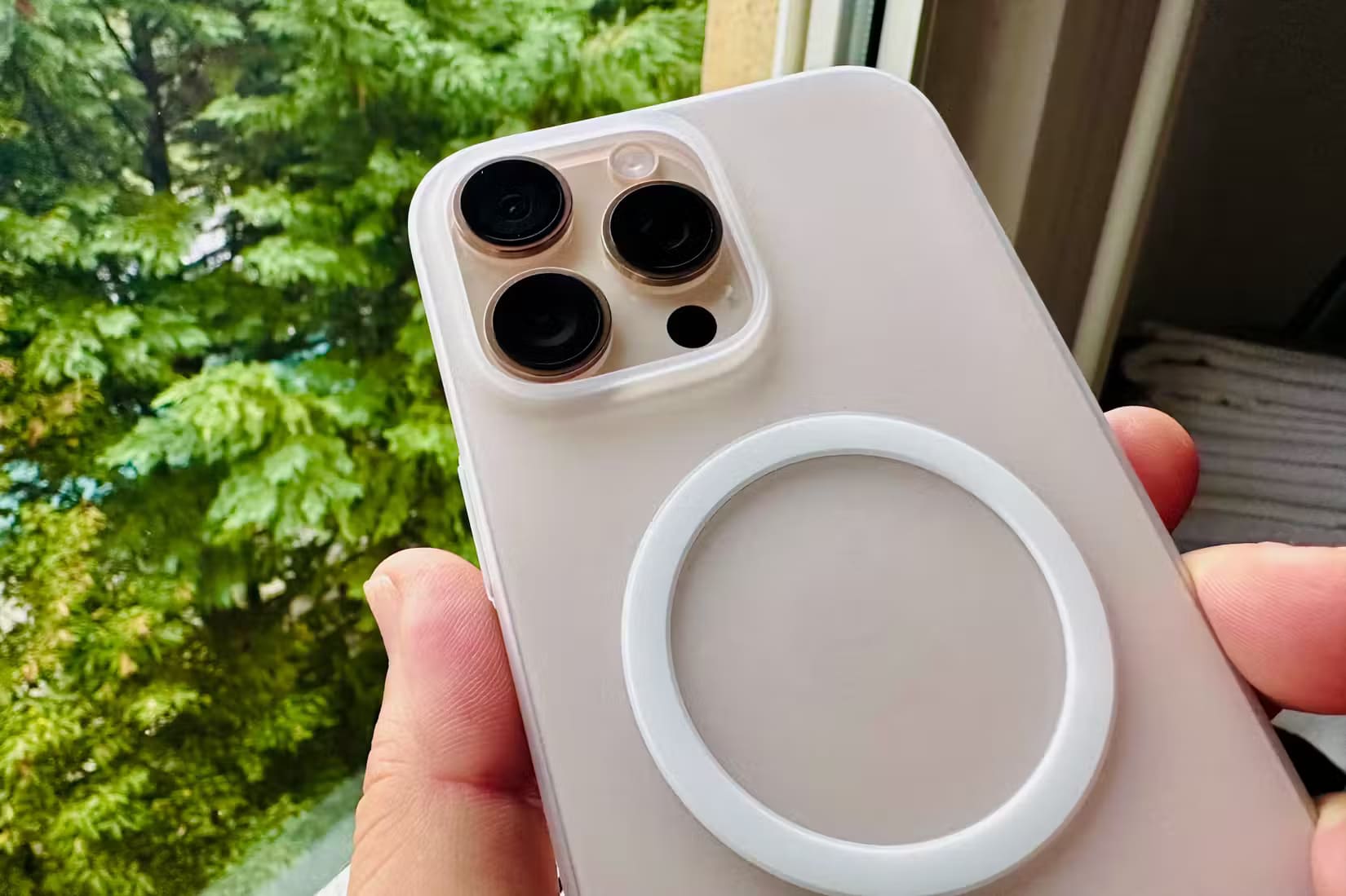 apple-iphone-16-pro-max-desert-titanium-backside-cameras-closeup-totallee-magsafe-clear-case-hand-room-window لماذا أنفقت مبلغًا إضافيًا من المال على شراء iPhone 16 Pro Max