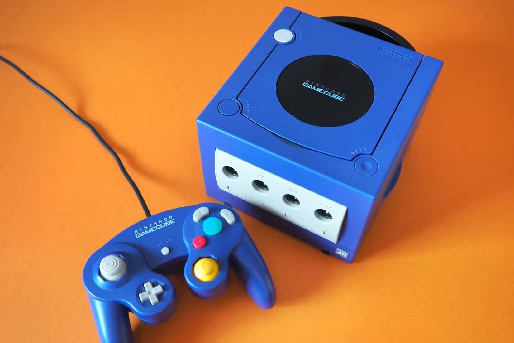 a-blue-nintendo-gamecube-on-an-orange-background 7 وحدات تحكم كلاسيكية يجب تجميعها قبل اختفائها من الأسواق
