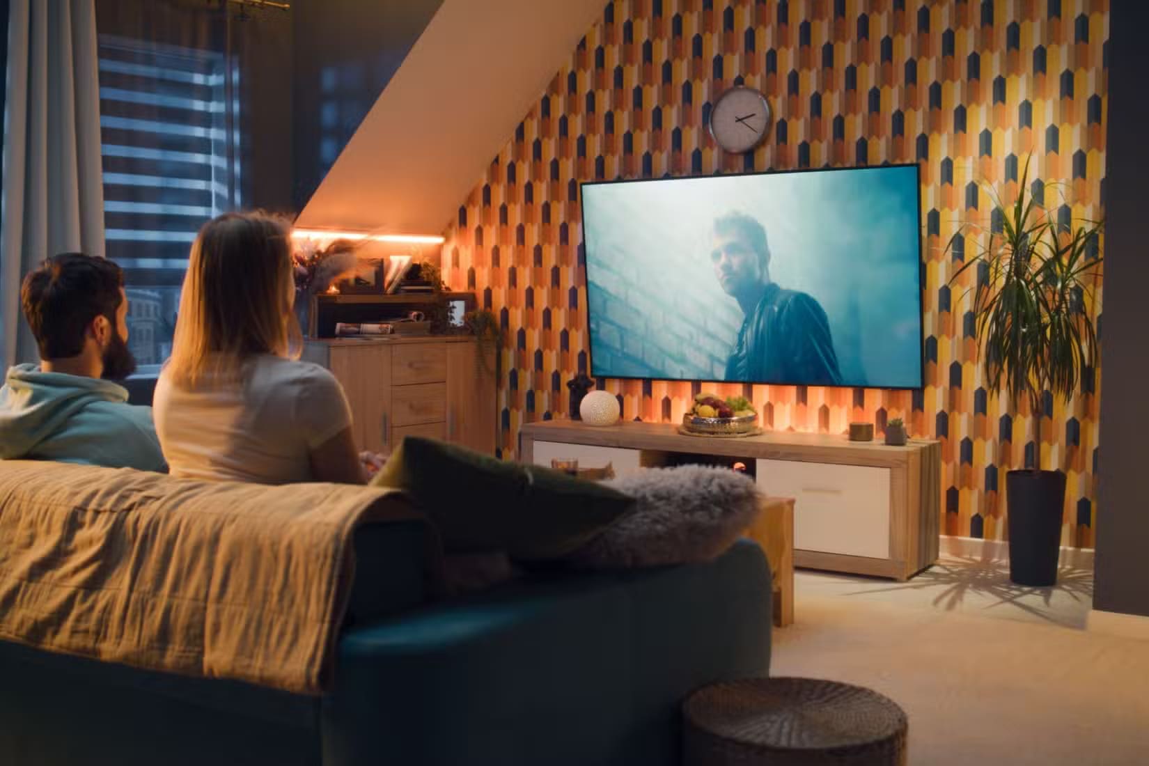 a-couple-watching-a-movie-on-a-home-theater-setup النطاق الديناميكي وأهميته في تحسين جودة الصور والفيديوهات