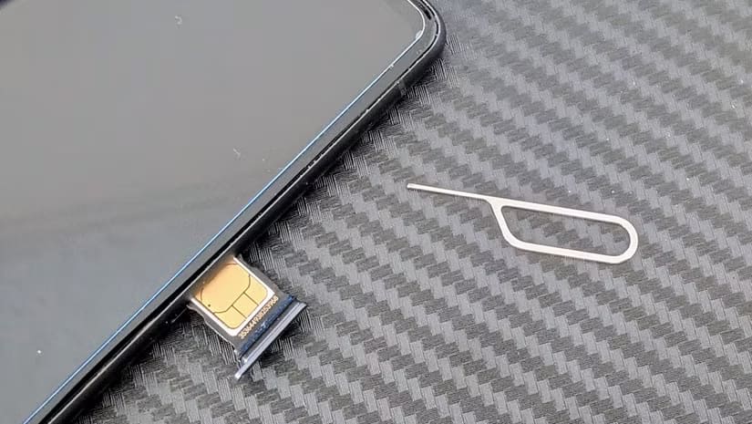 a-sim-tool-next-to-a-smartphone-with-the-sim-card-visible-in-its-tray حل مشكلة Sim Not Provisioned على هواتف Android بخطوات بسيطة