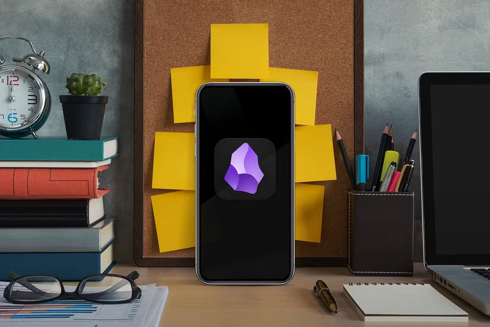 a-smartphone-on-an-office-desk-with-books-a-laptop-and-a-wall-with-several-notepads-behind تطبيقات شهيرة يظنها المستخدمون مفتوحة المصدر وهي ليست كذلك