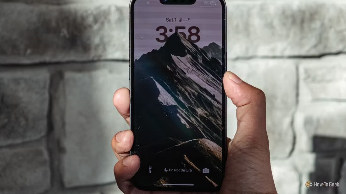 iphone-16e-in-hand-with-lockscree-1 طرق خفية يستخدمها iPhone لتتبعك وكيف توقفها بالكامل