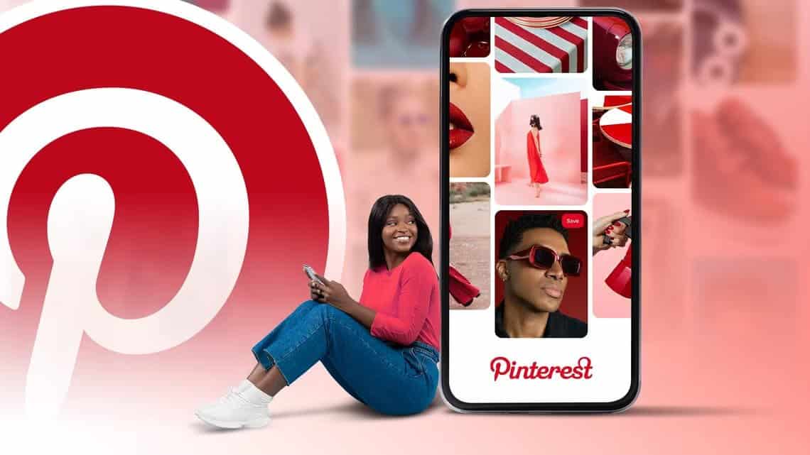 a-smiling-woman-sits-holding-her-phone-next-to-a-large-pinterest-logo-with-a-smartphone-screen-showing-vibrant-pinterest-pins أشياء لا تعرفها تجعل استخدامك لتطبيق Pinterest أسهل وأكثر تنظيمًا