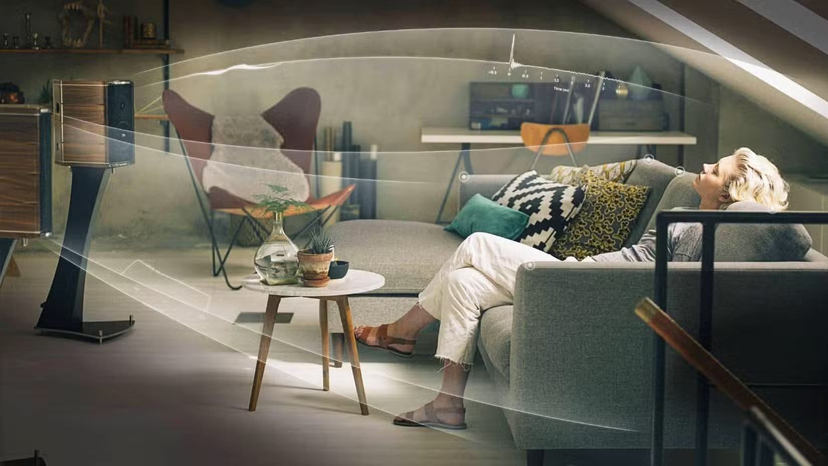 a-woman-sitting-on-her-couch-after-dirac-live-adjusted-her-speaker-settings طريقة بسيطة لتحسين صوت المسرح المنزلي باستخدام هاتفك