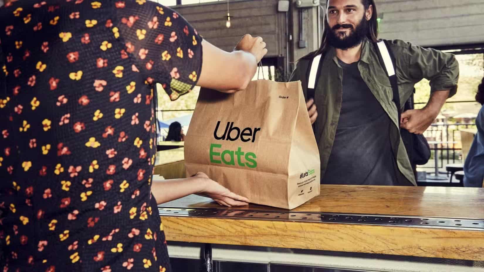 someone-picking-up-an-uber-eats-bag-full-of-food-from-a-restaurant تطبيقات Android أثبتت فعاليتها في كسب المال بدون رأس مال