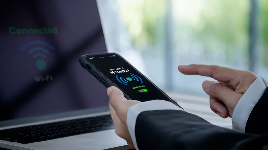 a-person-activates-their-personal-hotspot لماذا يعتبر الربط اللاسلكي أكثر أمانا وموثوقية من شبكات Wi-Fi العامة