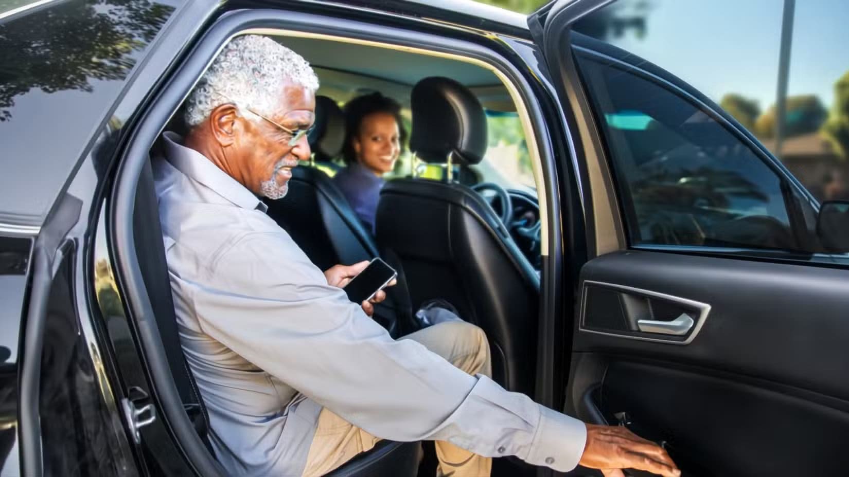 an-older-gentleman-getting-out-of-the-backseat-of-a-car-while-a-woman-looks-back-at-him-smiling أفضل استخدامات مبتكرة للشاشة المحمولة في حياتك اليومية