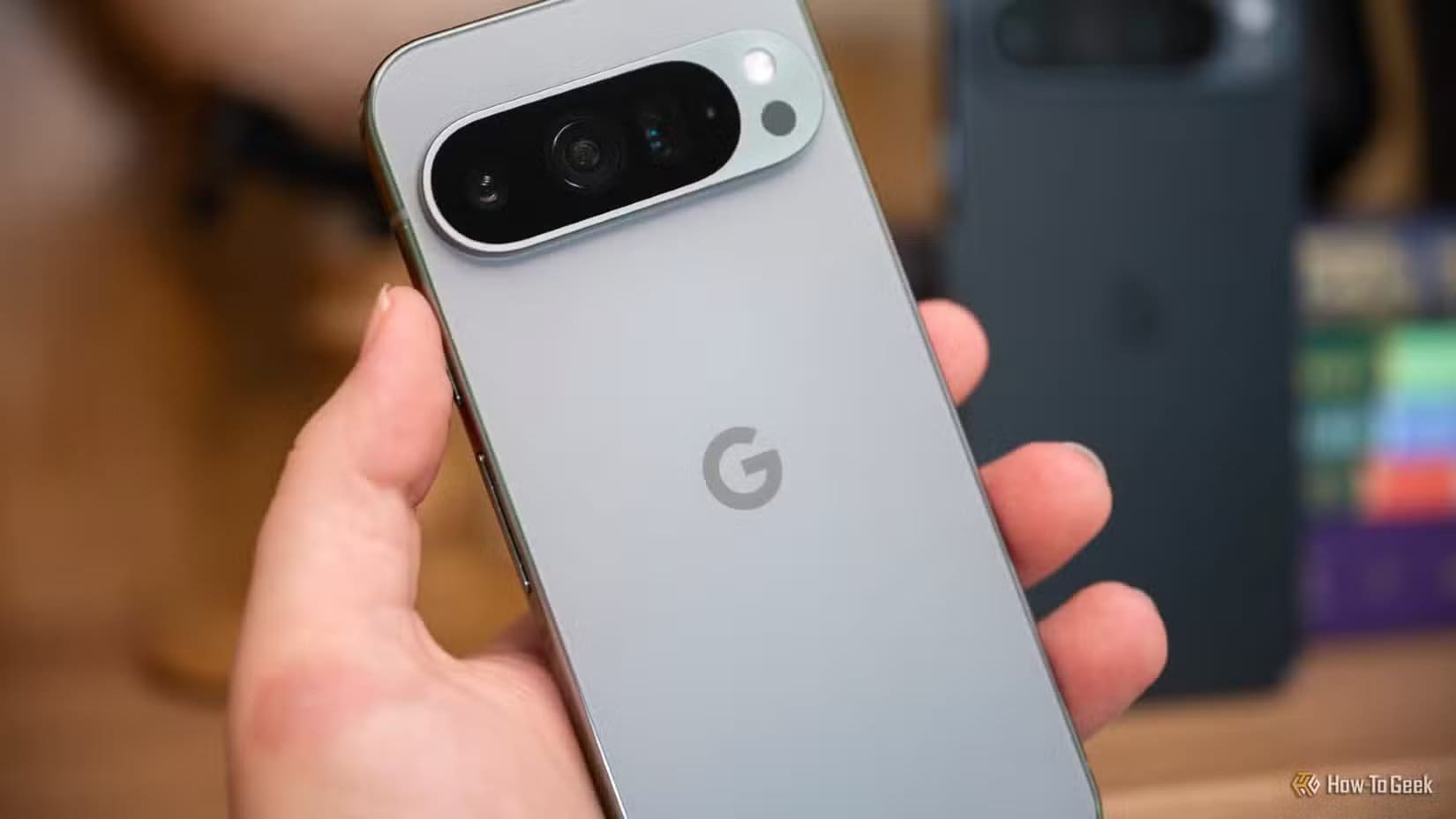 person-holding-the-google-pixel-9-pro-in-front-of-the-9-pro-xl-1 قائمة هواتف Pixel التي لن تحصل على تحديث Android 16