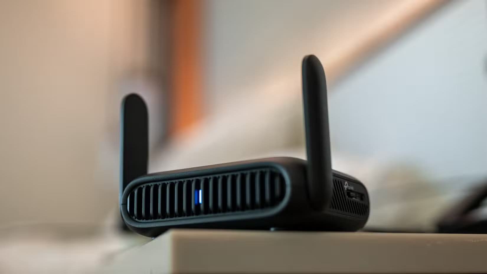 tp-link-be3600-wi-fi-travel-router-sitting-on-a-table-in-a-hotel-room طرق آمنة للوصول إلى خادم Home Assistant من أي مكان
