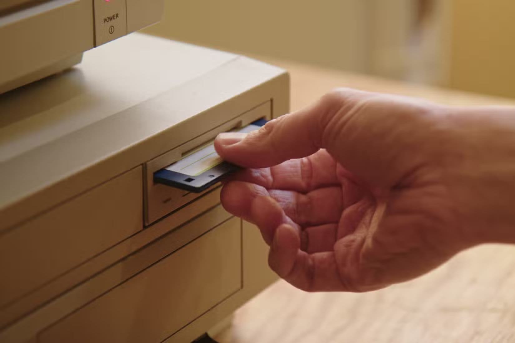 hand-inserting-and-ejecting-floppy-disk-into-vintage-commodore-amiga-2000 جوهر البرمجيات المفتوحة وكيف تتجاوز فكرة المجانية تمامًا