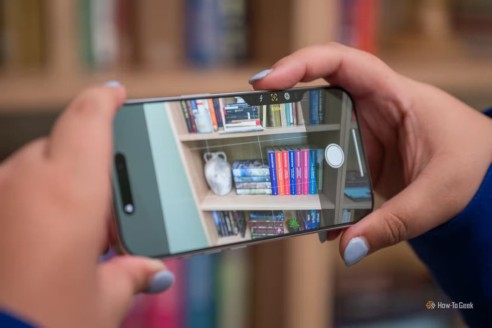 person-taking-a-picture-with-the-apple-iphone-16-pro-camera-control-button-in-landscape-1 تجنّب فقدان جودة صورك بعد النسخ الاحتياطي في تطبيق Google Photos