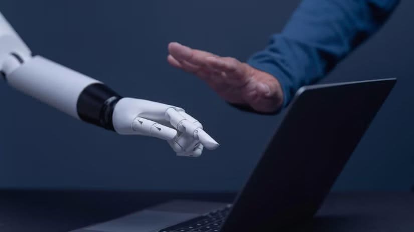 Man-Blocking-Robot-Hand-Above-Laptop أدوات مفتوحة المصدر تمنحك تحكمًا أوسع في ويندوز 11