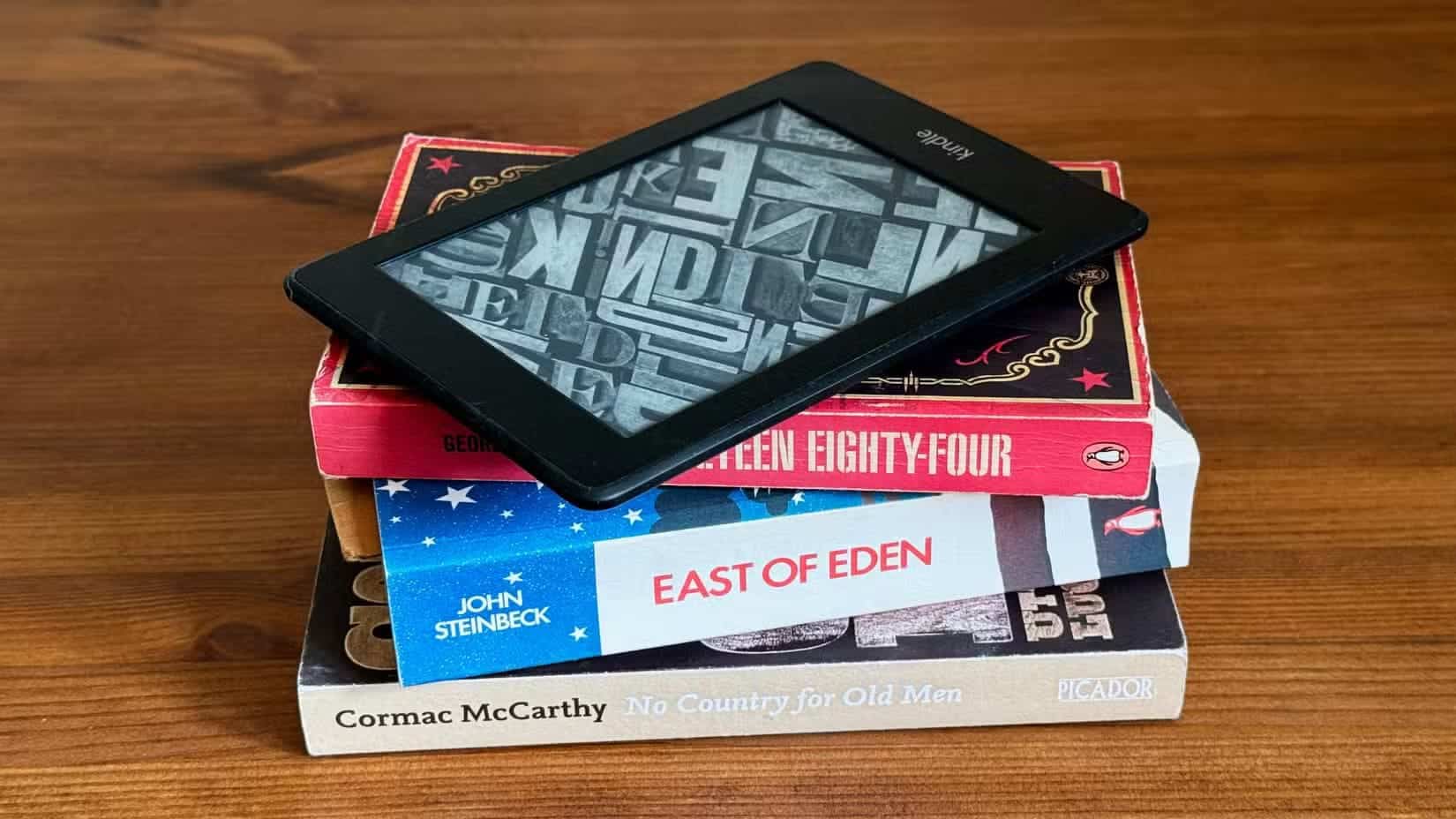 a-stack-of-books-with-a-kindle-ereader-on-top-of-them لماذا يجب تفعيل وضع الطيران في كيندل لتحسين القراءة وتوفير البطارية