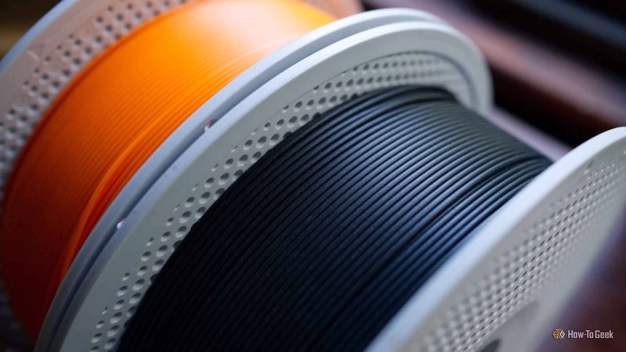 a-roll-of-black-pla-matte-and-basic-pla-orange-3d-printer-filament-scaled 5 طرق ذكية لربط الطابعة ثلاثية الأبعاد بالمنزل الذكي والاستفادة منها يوميًا