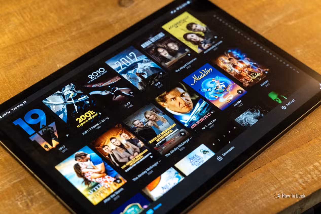 angled-ipad-view-of-jellyfin-movie-poster-grid-on-a-wood-table-1 3 تطبيقات مجانية مفتوحة المصدر تغنيك عن الاشتراكات المدفوعة