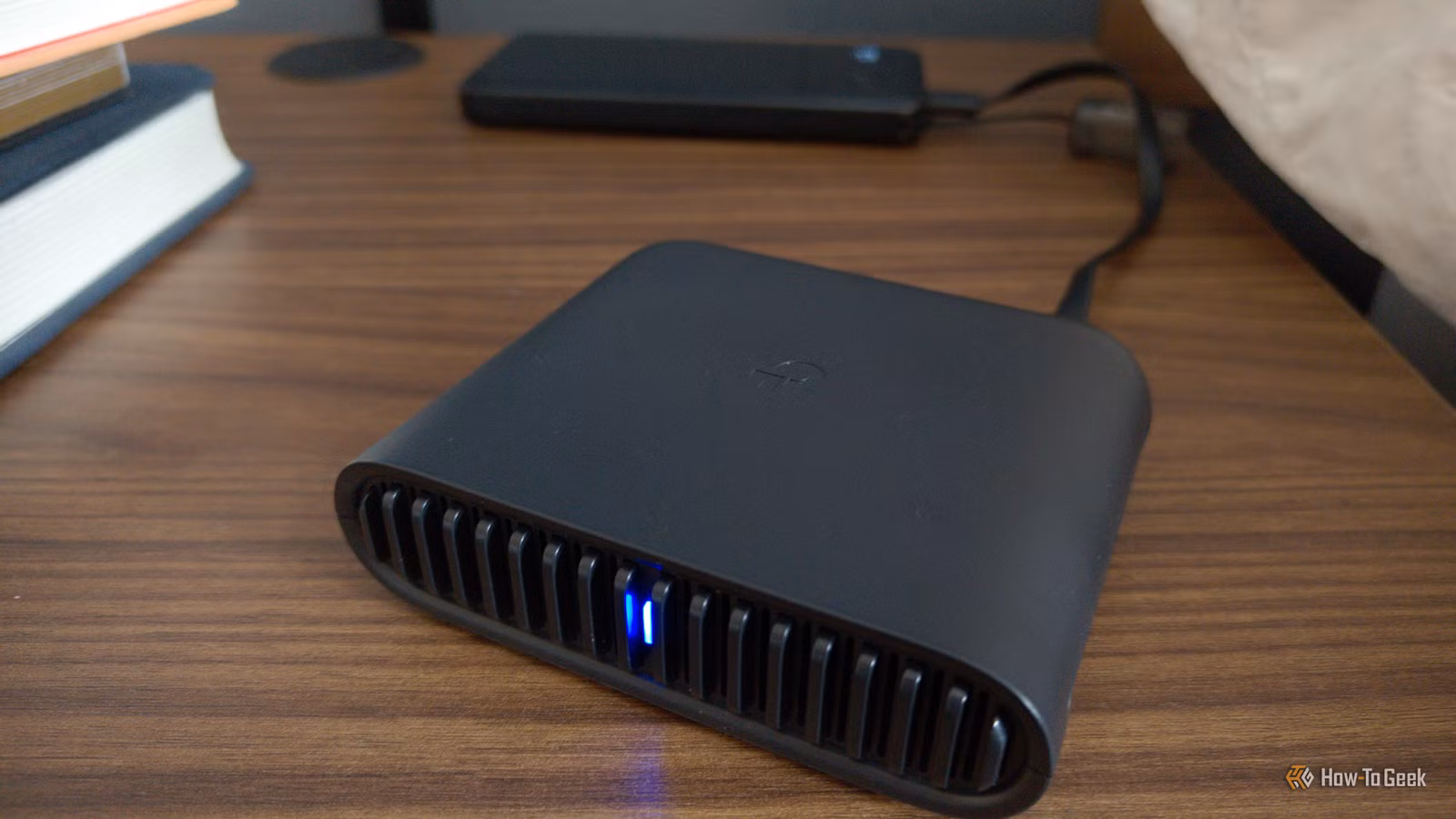 tp-link-travel-router-on-a-side-table-next-to-books 6 طرق فعالة لتحسين سرعة واستقرار شبكة الواي فاي في المنزل